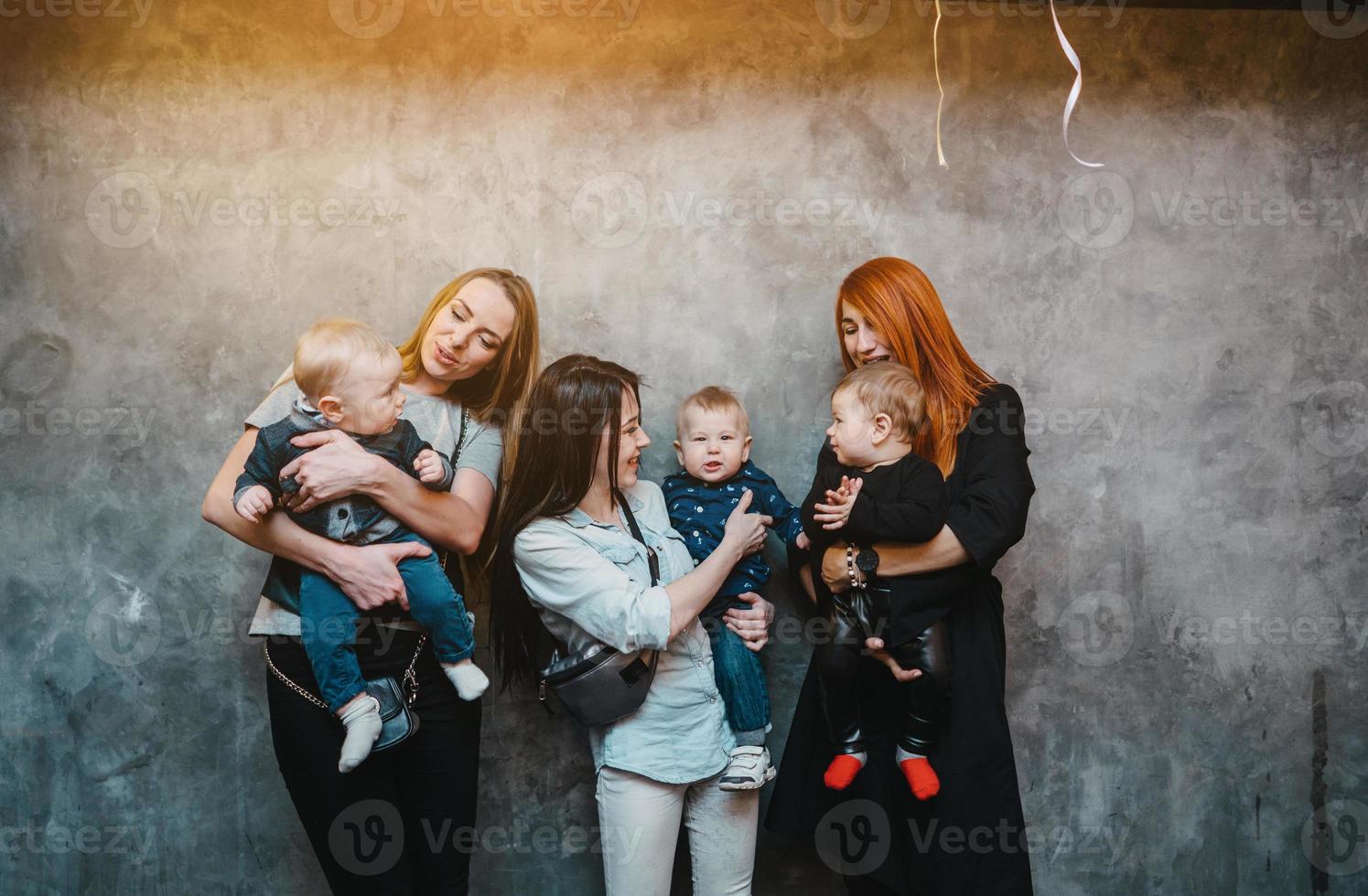 Three moms with their children posing on camera photo