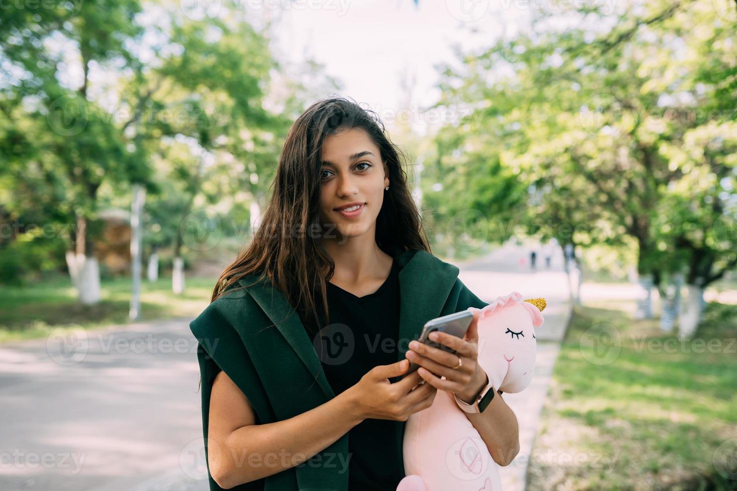 Young Attractive Girl Typing Messages on her Mobile. photo