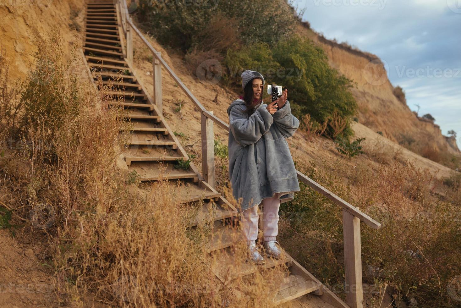 Young woman takes a photo on a smartphone of the seascape