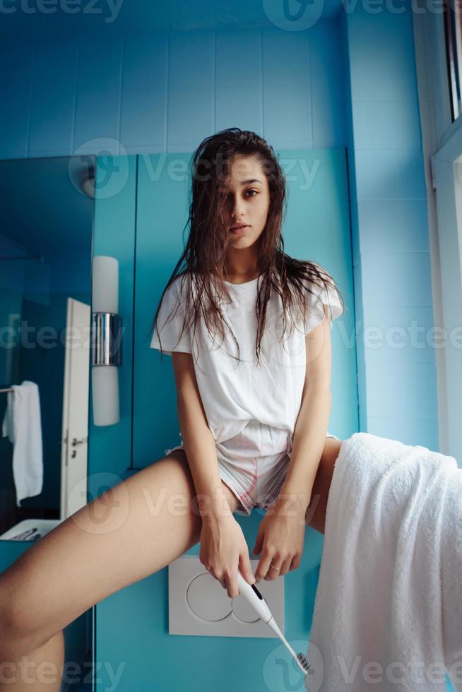 Beautiful, young woman in the bathroom is having fun photo