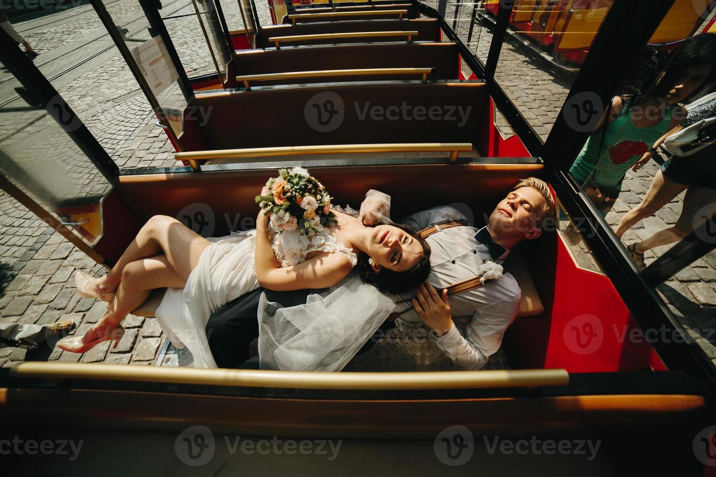 novia y novio posando en un auto turístico foto