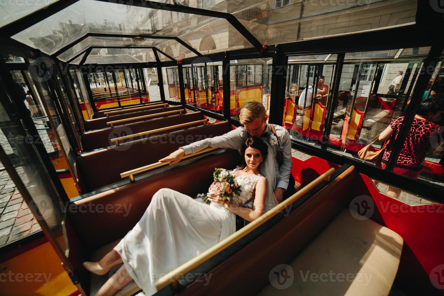 Bride and groom posing in a tour car photo