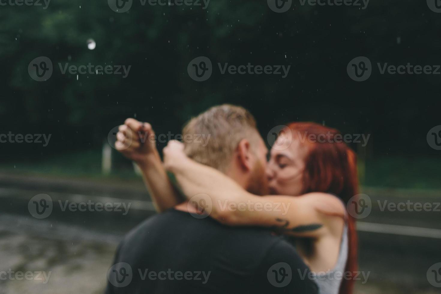 beautiful couple kissing  in the rain photo