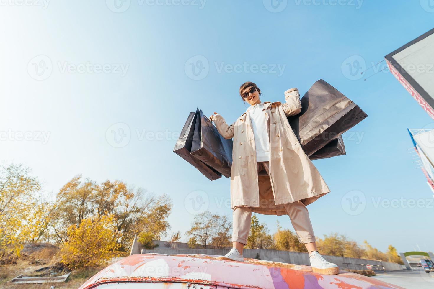 A young woman is standing in a car with bags in her hands photo