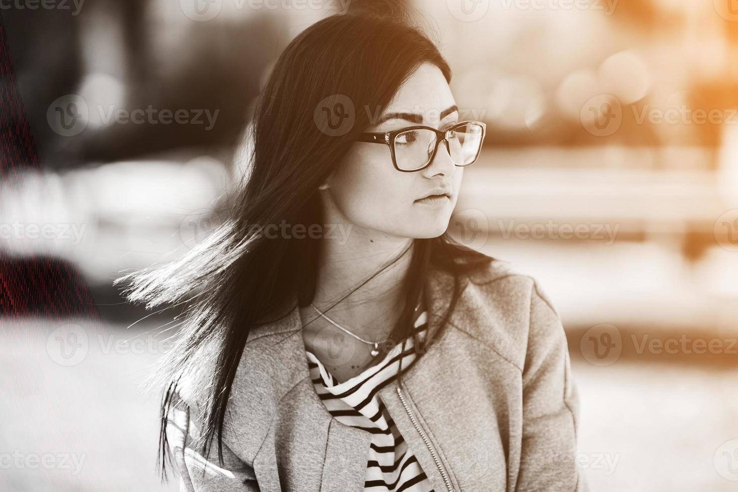 Beautiful model in glasses sit on the fence photo