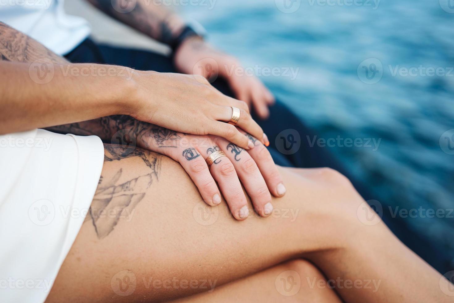 Young couple are sitting on the pier by the sea photo