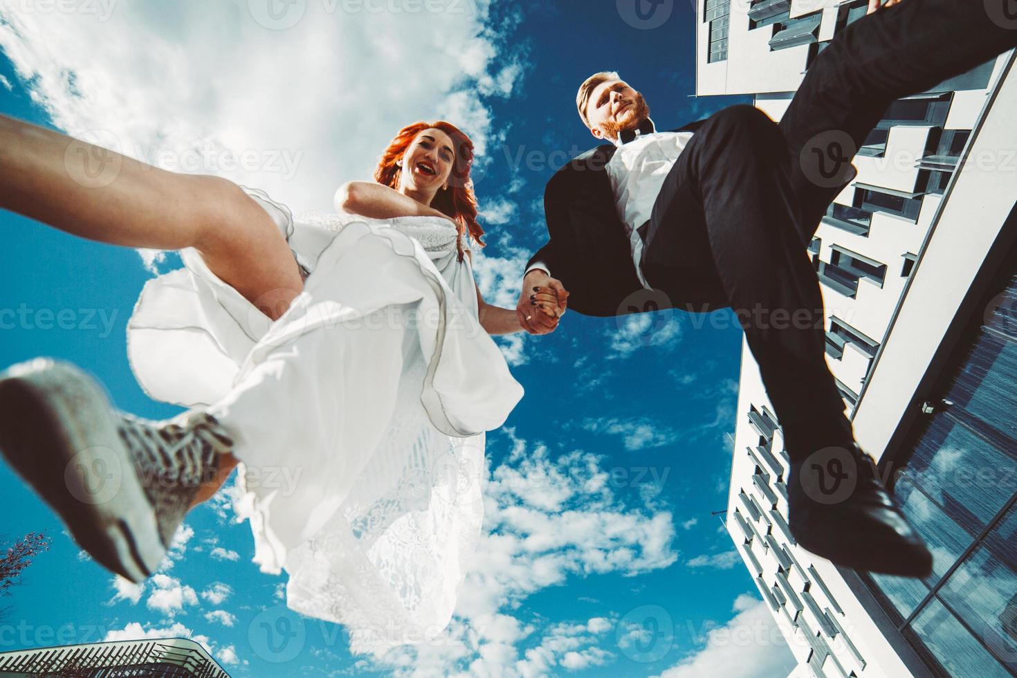 Wedding couple jumping in a futuristic building photo