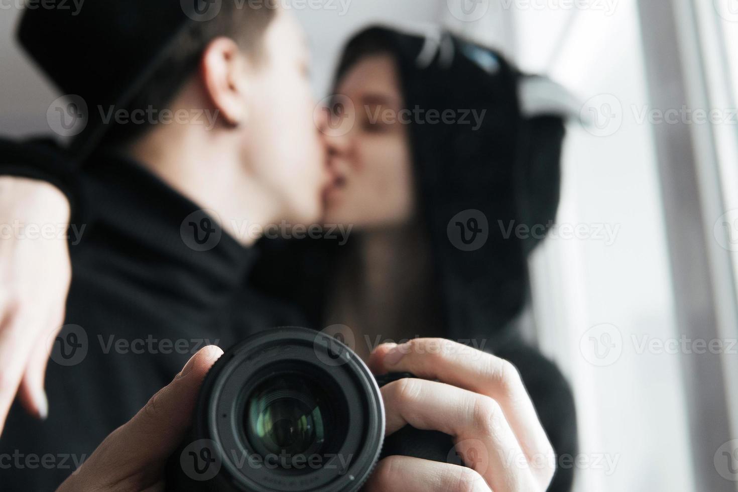 man and woman in black clothes kissing photo