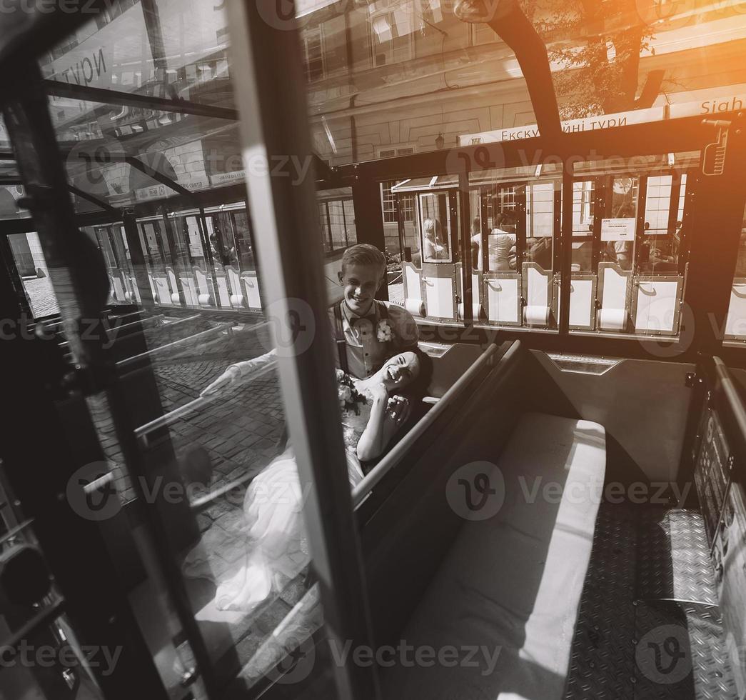 Bride and groom posing in a tour car photo