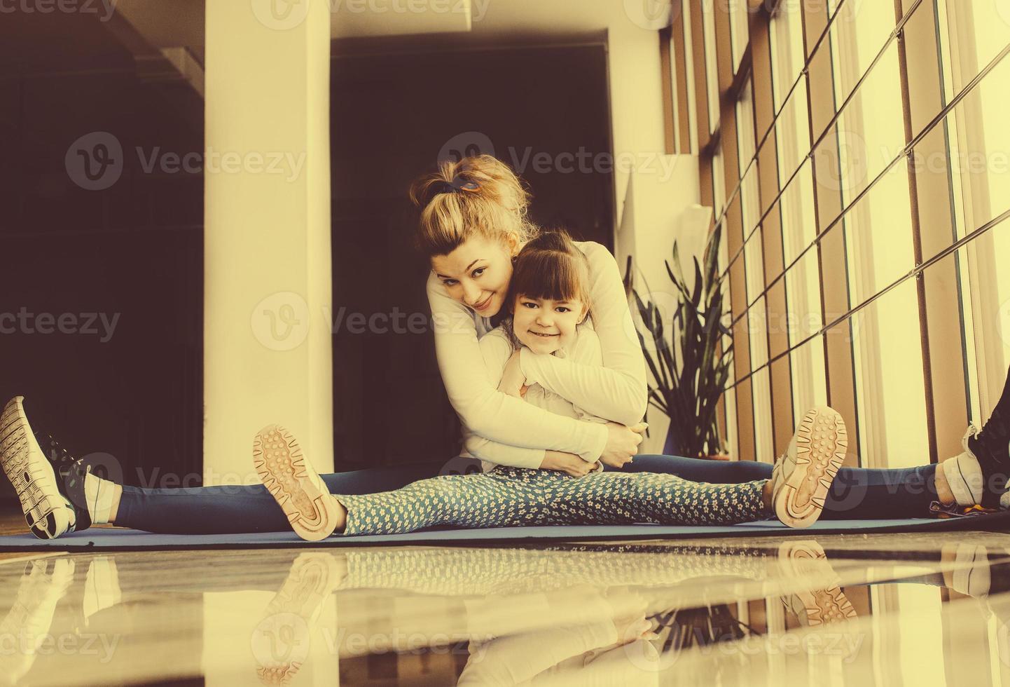 Mother and daughter hugs and stretch in the gym photo