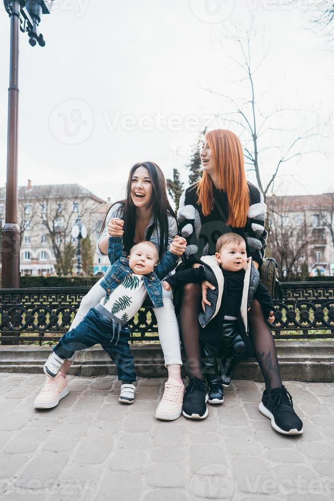 dos mamás y sus dos hijos posando en cámara foto