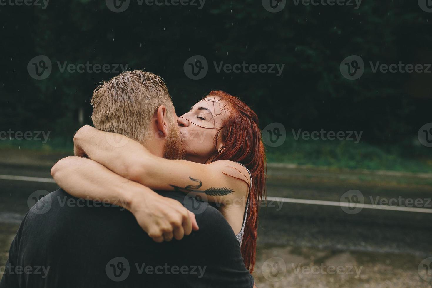 hermosa pareja besándose bajo la lluvia foto