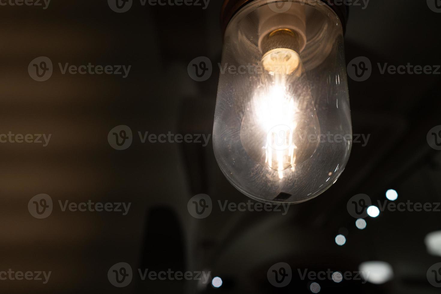 Glowing vintage light bulb from close perspective in the dark photo