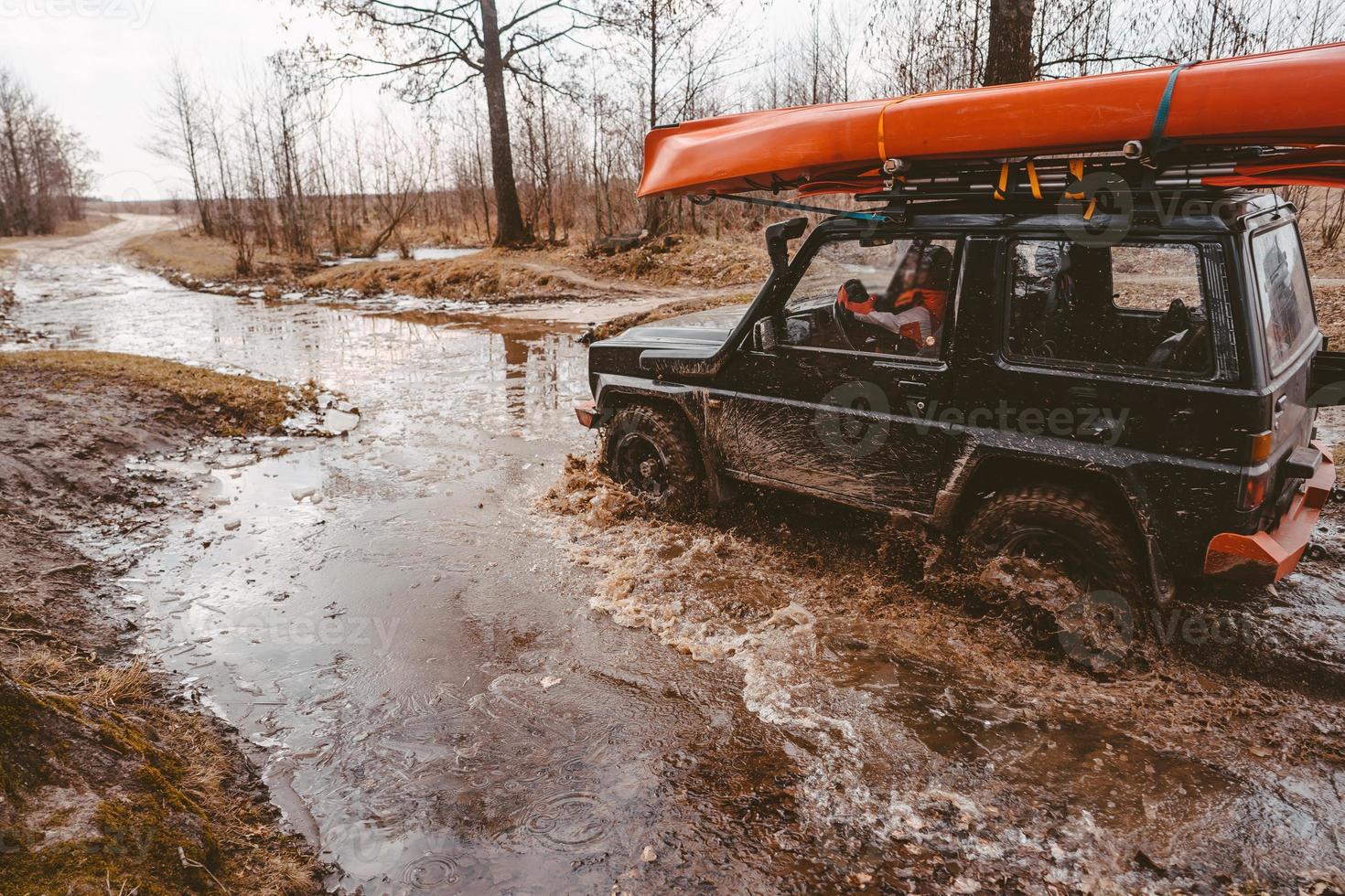 Off-road travel on dirt road road, water splash. photo