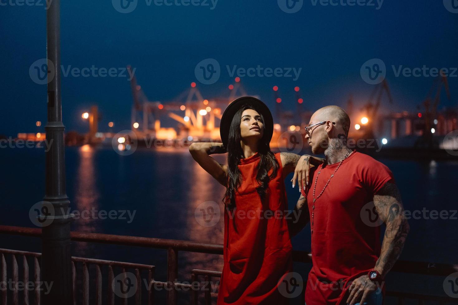 Young guy and beautiful girl on the background of the night port photo