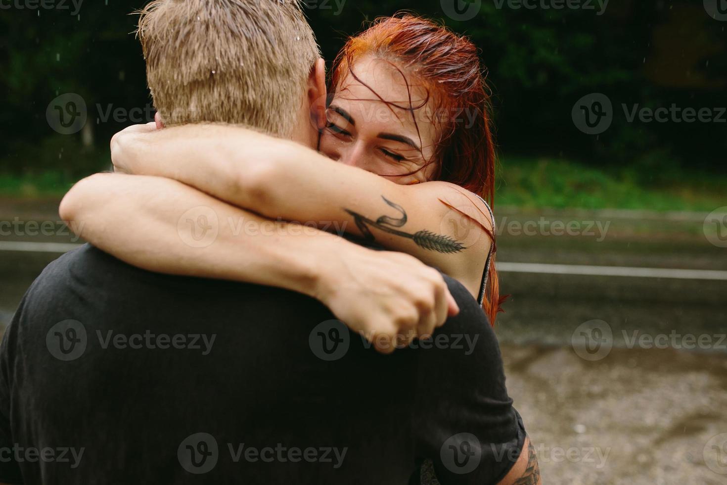 beautiful couple hugging in the rain photo