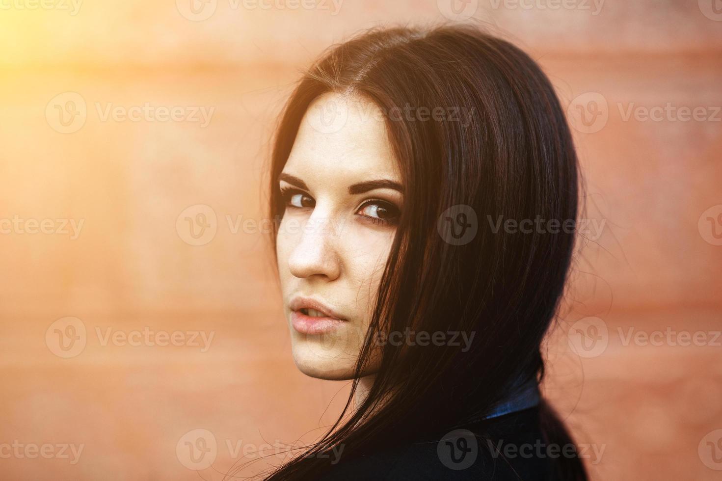 Beautiful female model posing against the wall photo