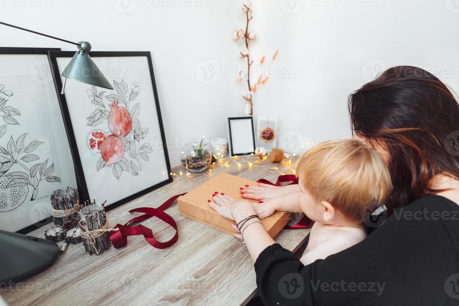 mamá e hijo pequeño empacan un regalo foto