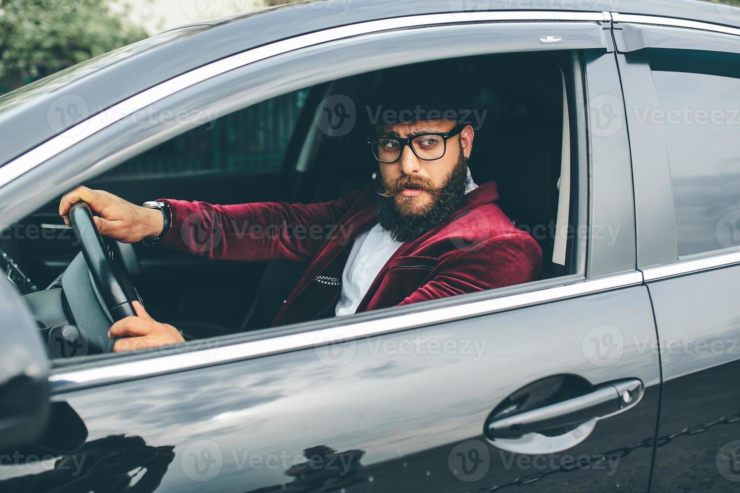 Man with beard driving a car photo