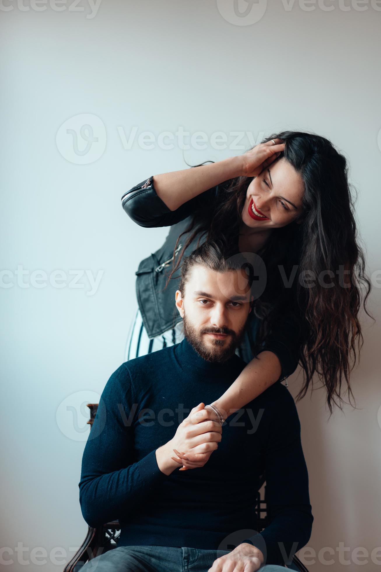 Guy sitting on a chair, girl standing behind him 11522639 Stock Photo