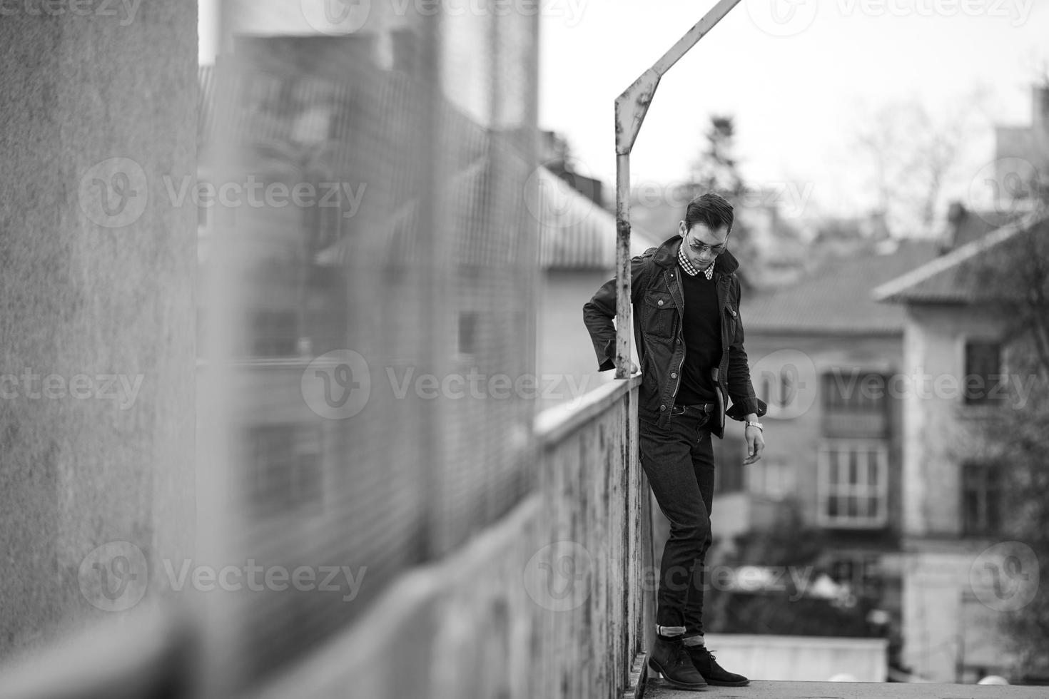 A man dressed in jeans on the background of the train and the station photo