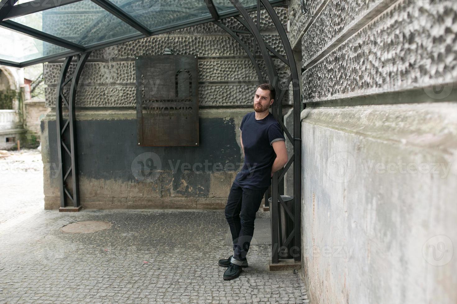 The man in the authentic boots and selvedge jeans  on a background of old city photo