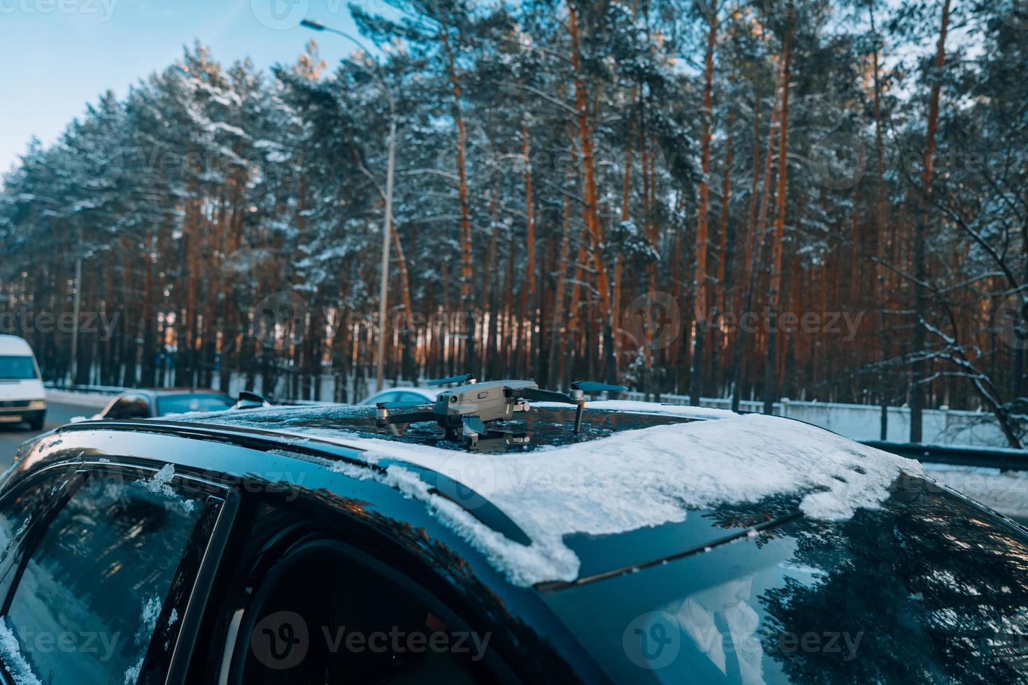 Drone standing on the roof of a snow-covered car photo