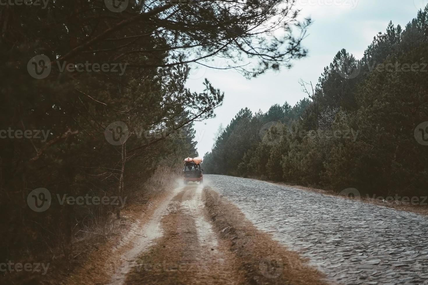 SUV rides on a dirt road, evening photo