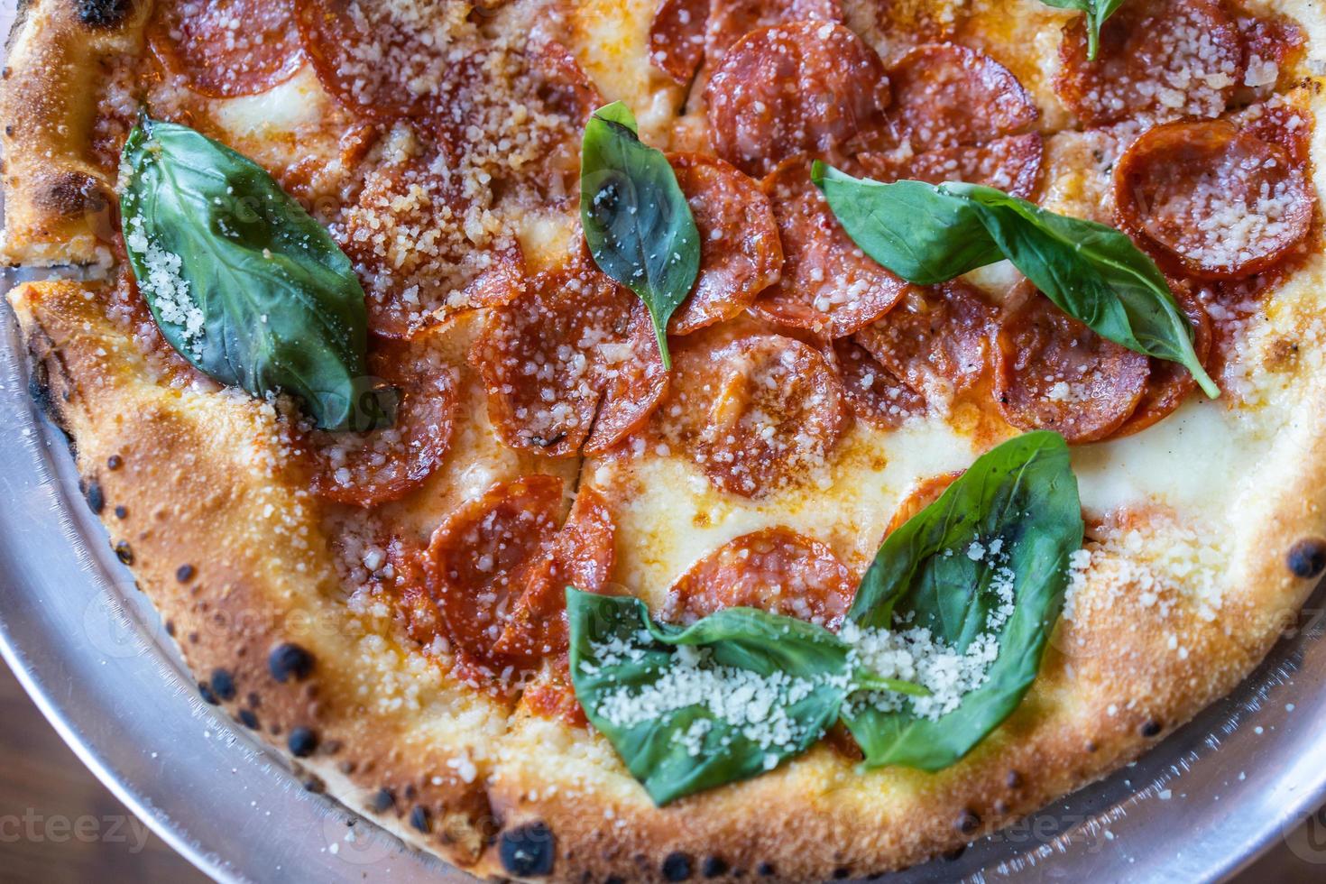 pizza con salchicha y albahaca, vista cercana foto