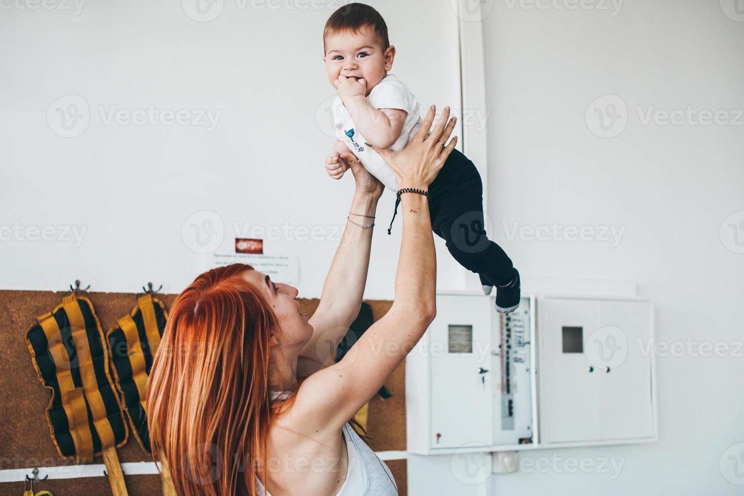 joven madre con su hijo pequeño en el gimnasio foto