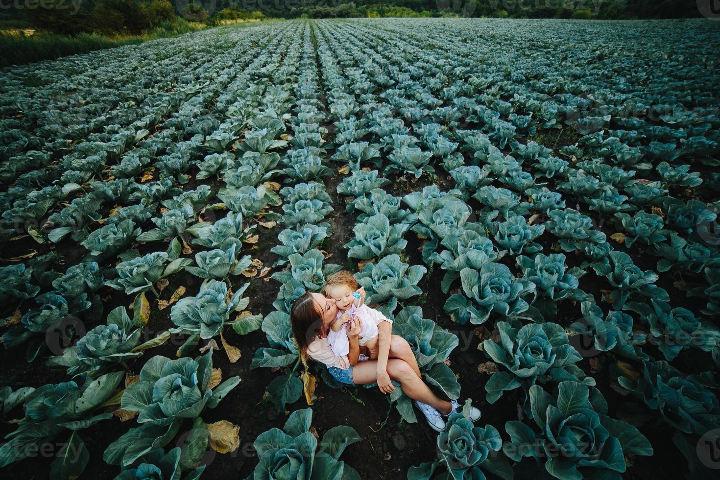 Mother and daughter on the field with cabbage photo