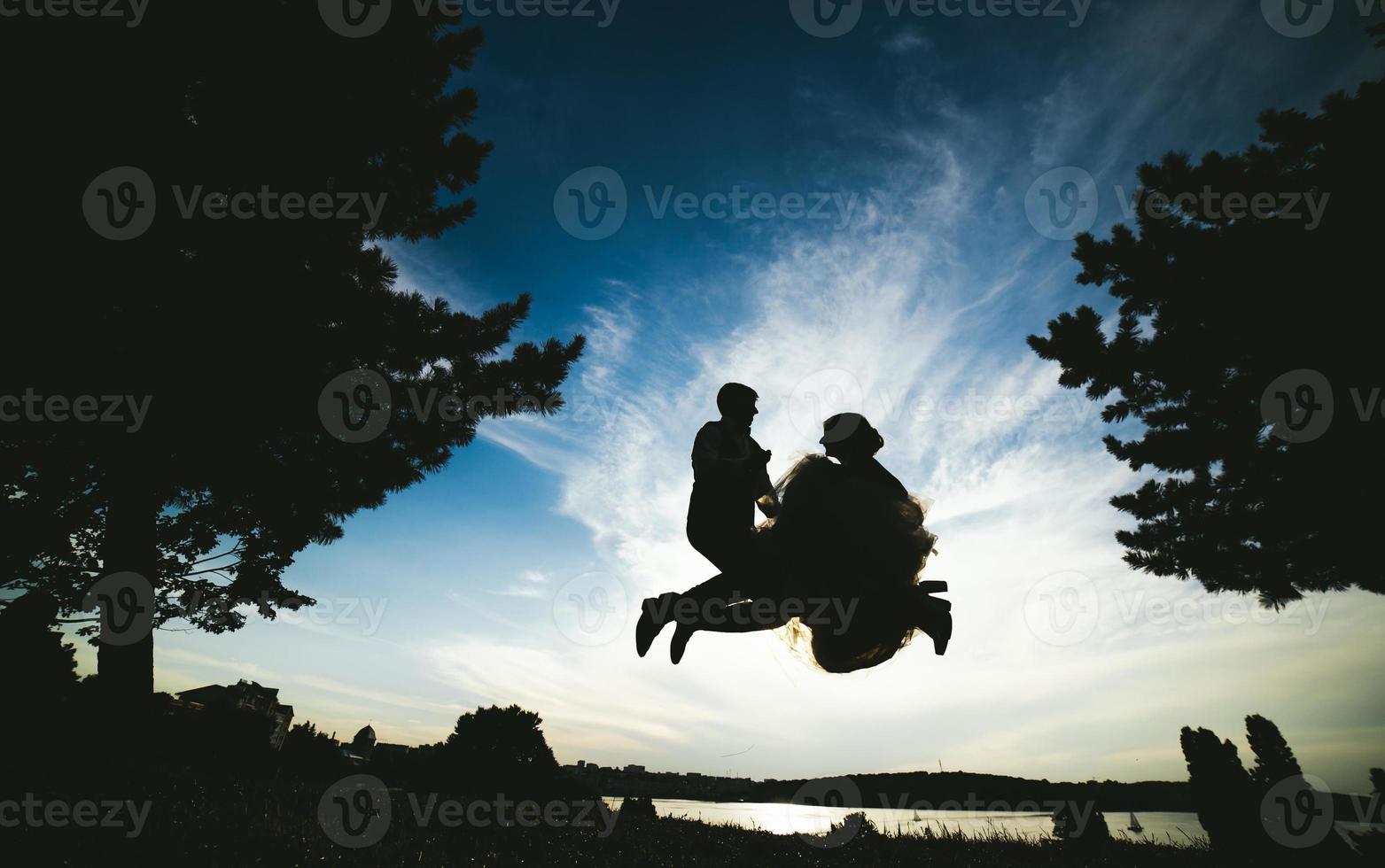 novio y novia saltando contra el hermoso cielo foto