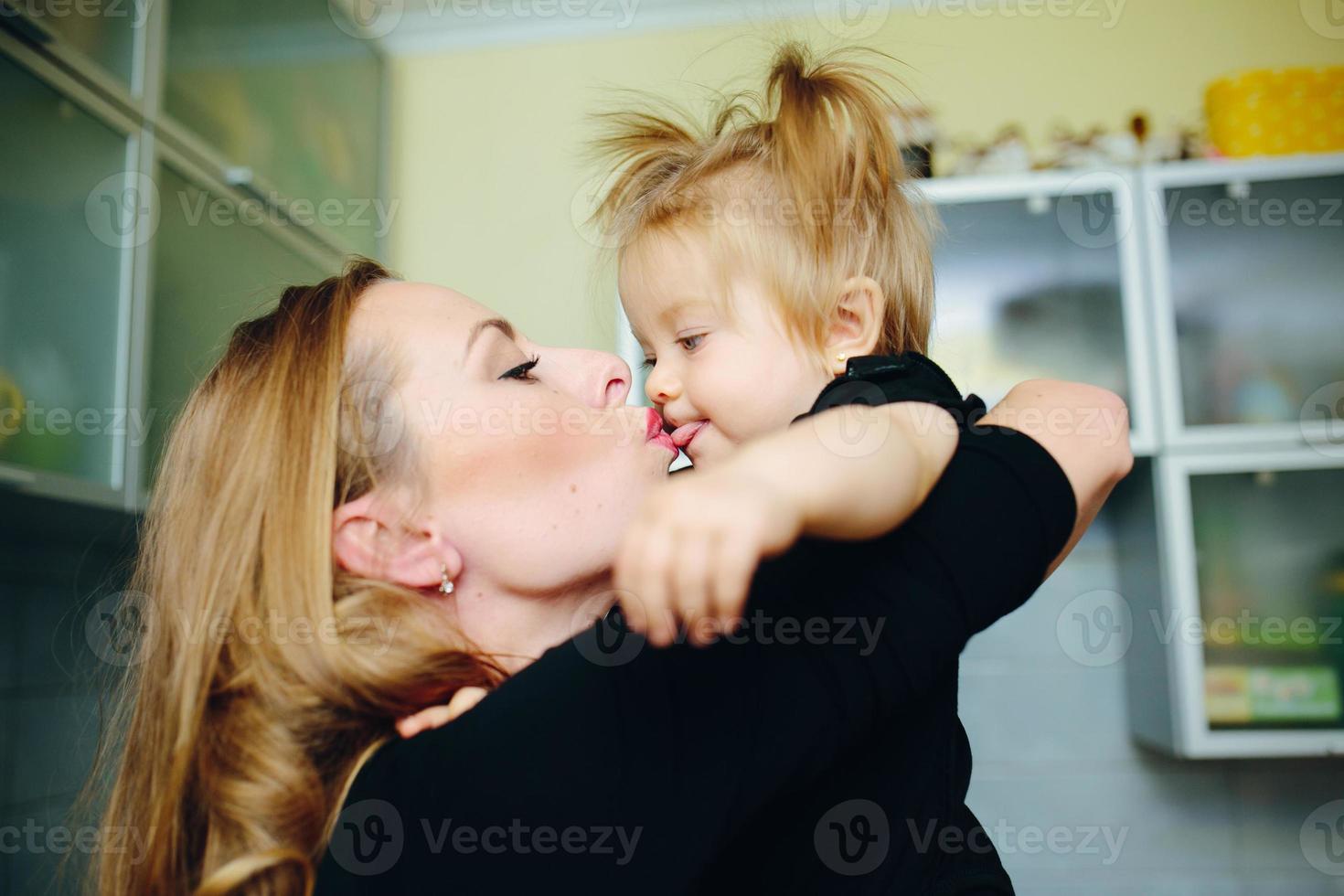Mother with daughter standing in kitchen photo