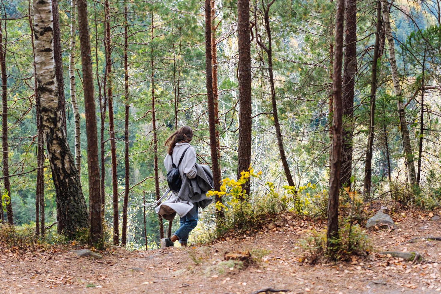 la niña camina por el bosque foto