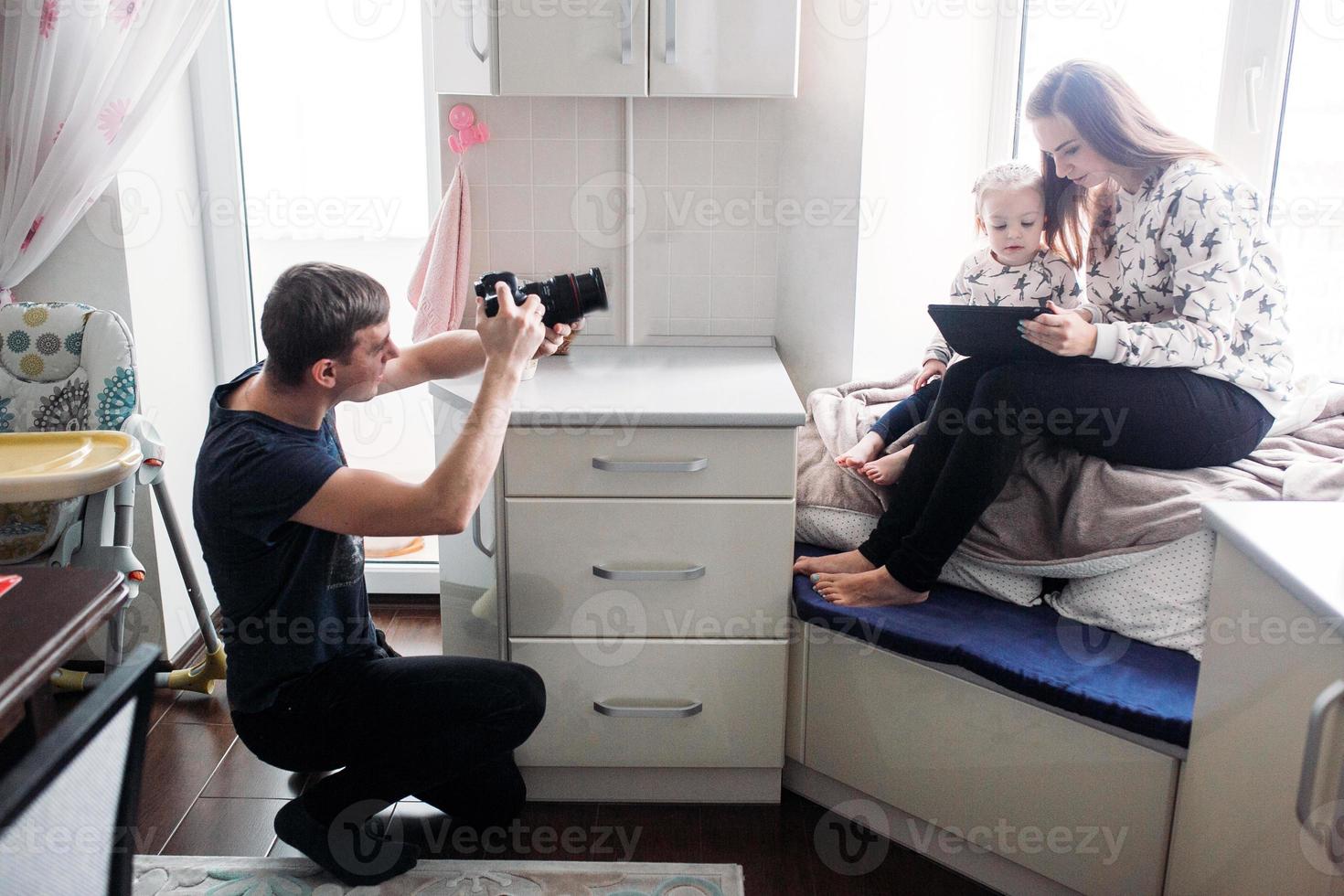 padre tomando fotos de su hija y esposa