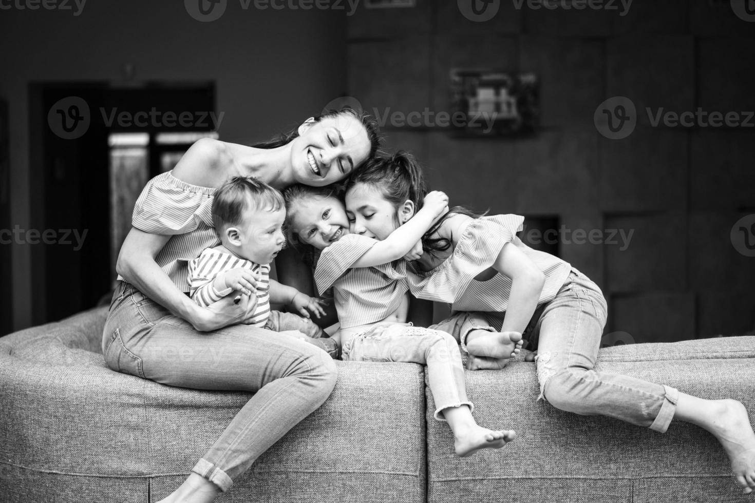 Mom, two daughters and a little son on the couch photo
