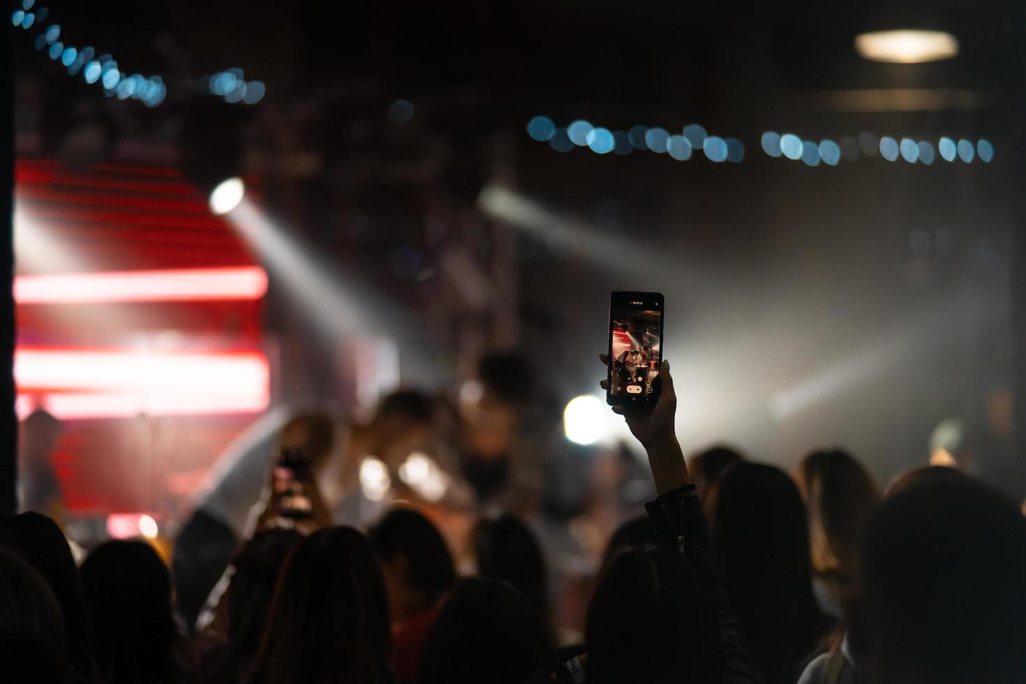 Person close up of recording video with smartphone during a concert. photo