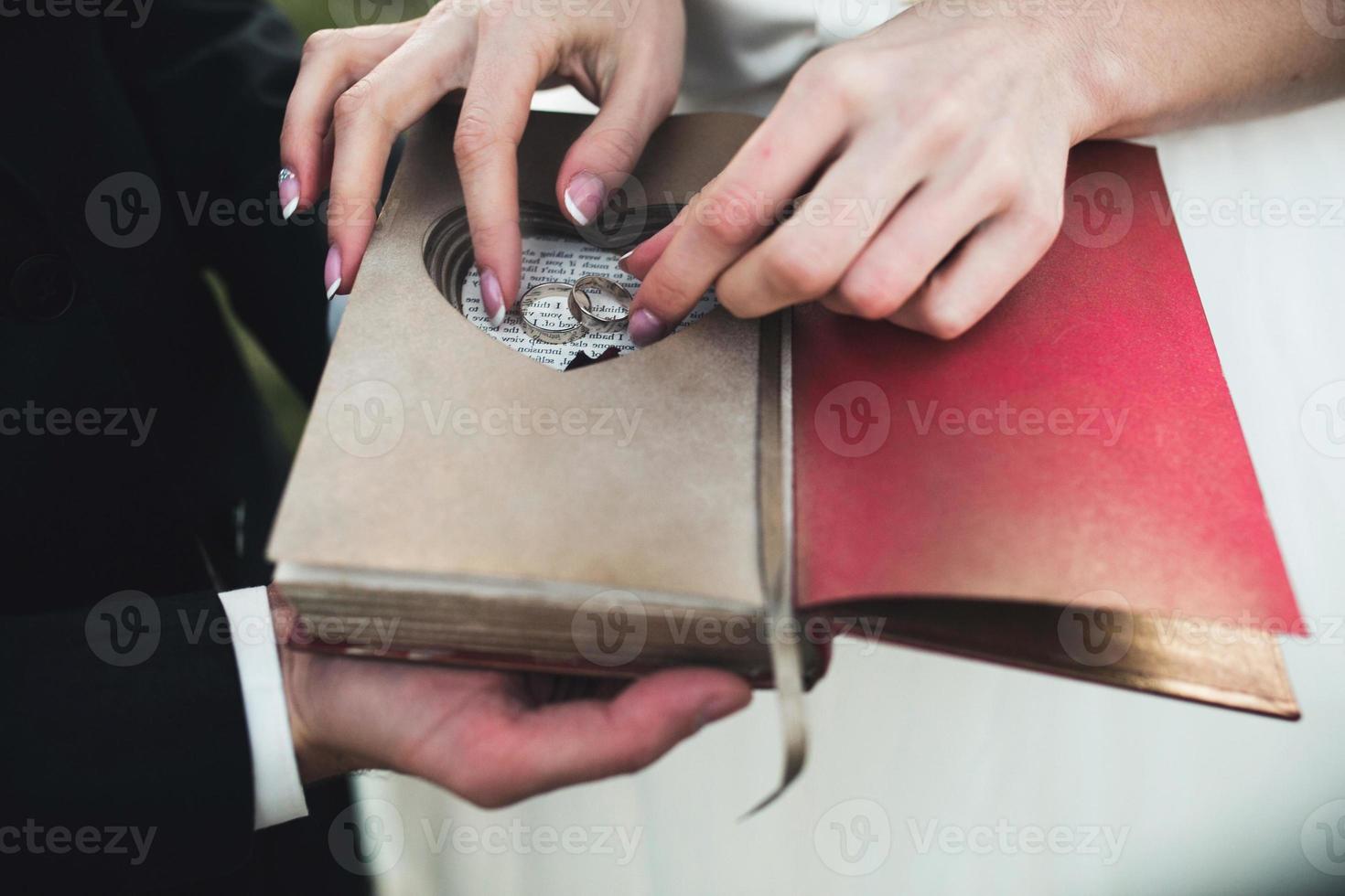 encantador libro vintage con corazón hecho a mano en el que descansa el anillo. foto