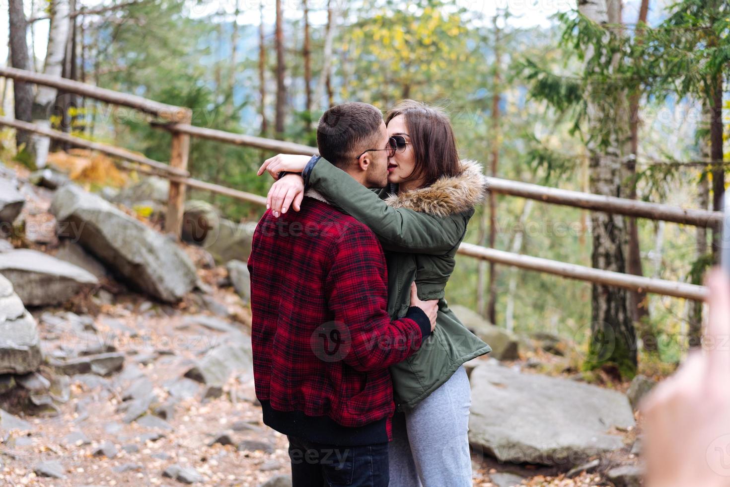 girl and a young man kissing in the woods photo