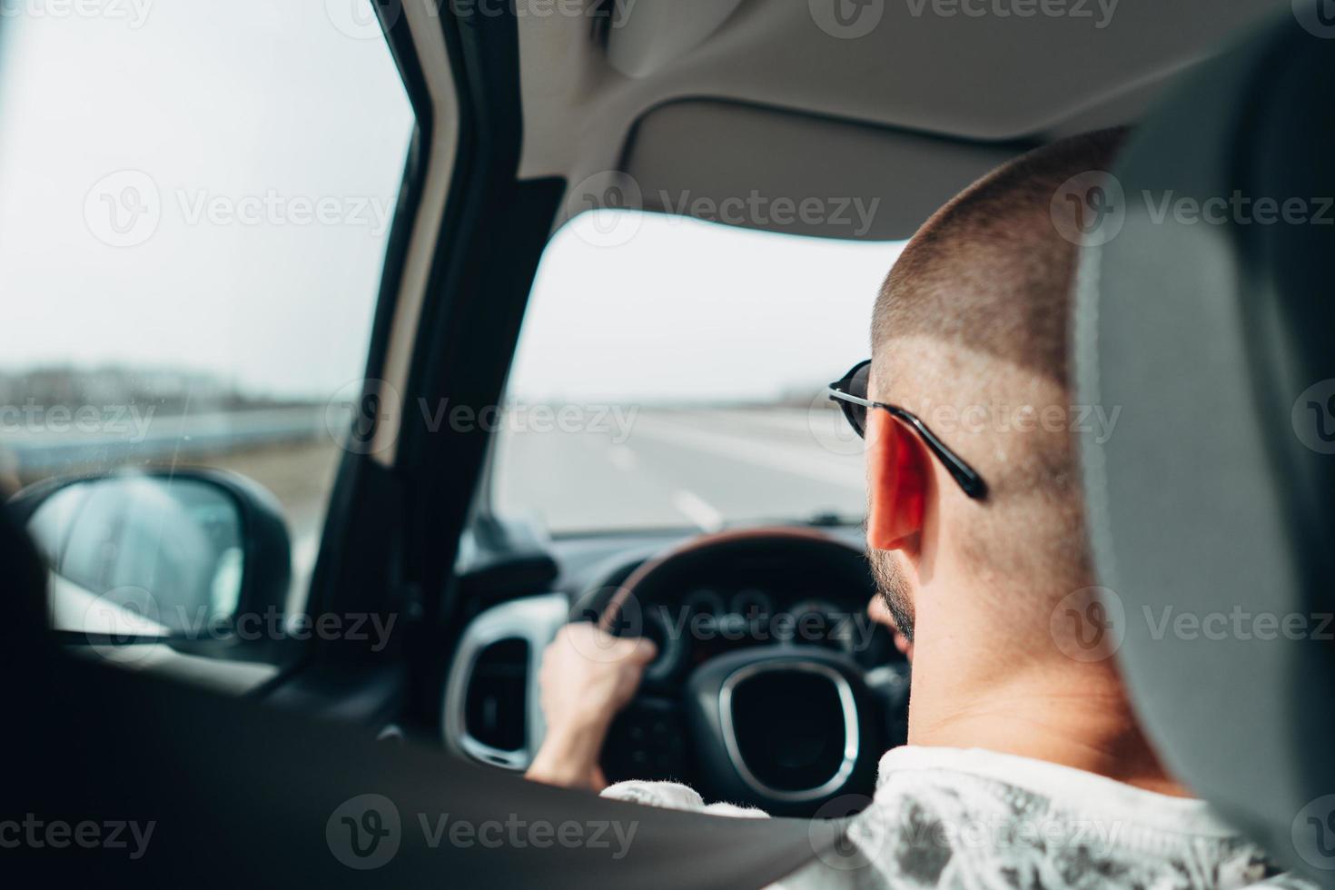 The man in the car traveling on the road photo