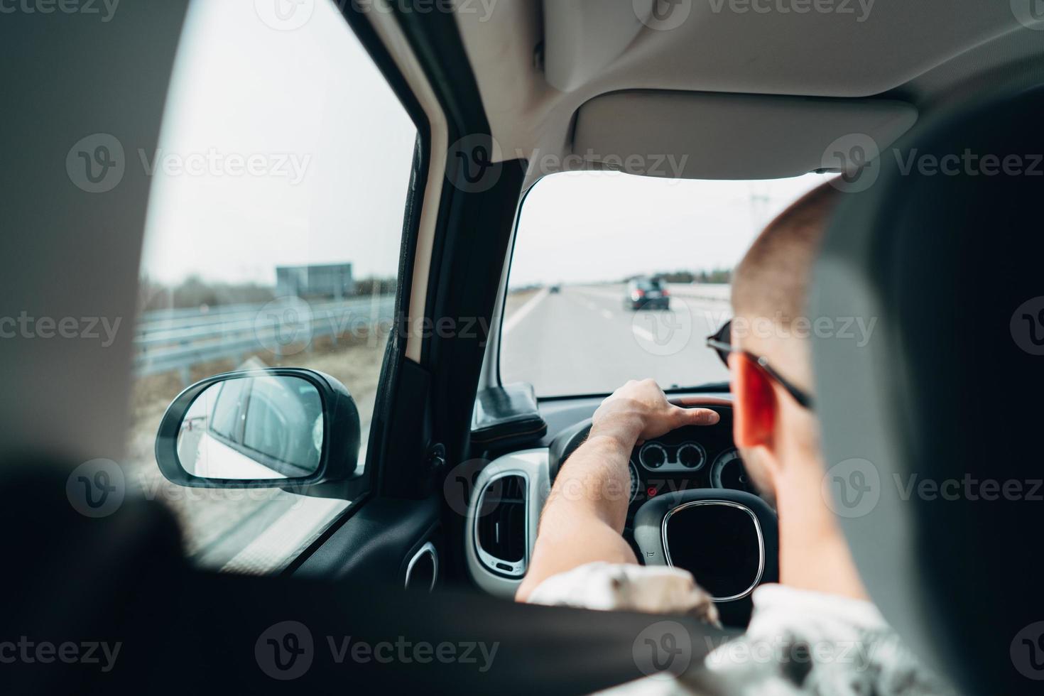 The man in the car traveling on the road photo