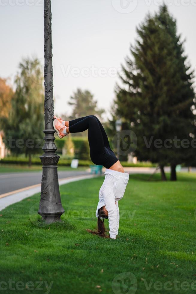 atractiva mujer flaca haciendo un backbend mientras muestra un salto mortal. foto