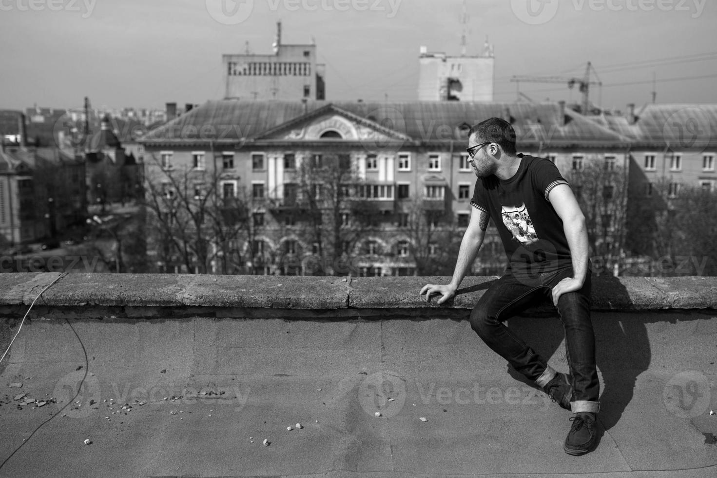 The man in the authentic boots and jeans selvedge on the roof of the building in the old town photo