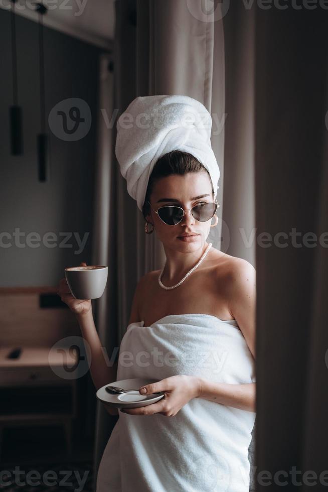 Girl wrapped in a towel drinking coffee photo