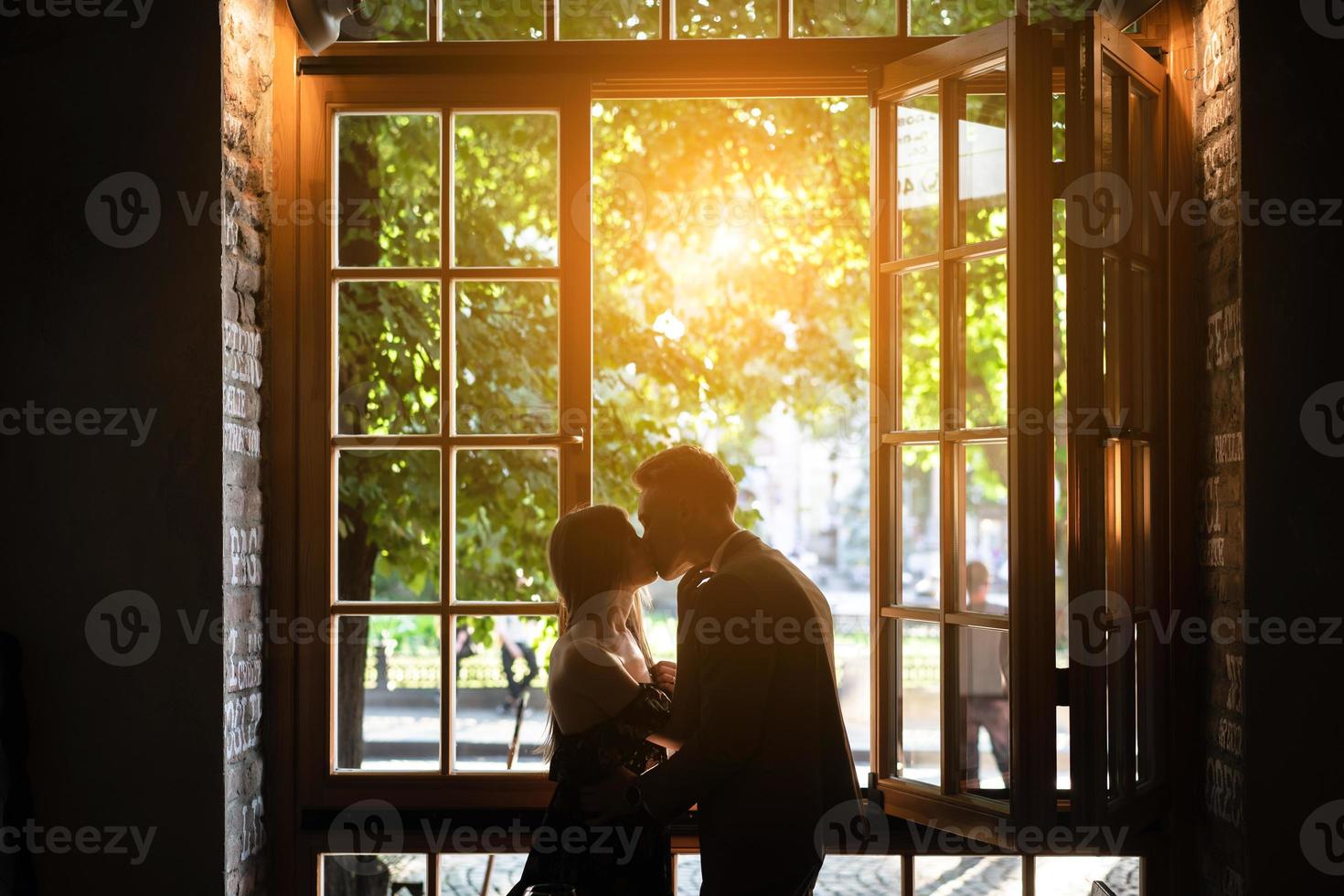 Young couple in love standing by the window photo