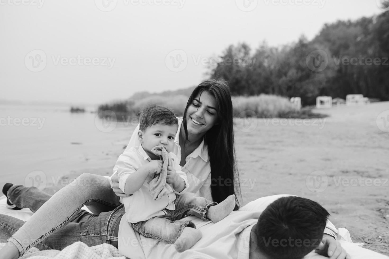 Happy young family relaxing together on the lake photo