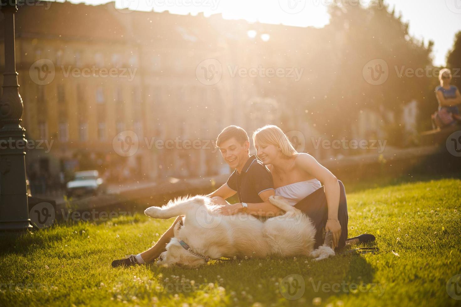 Boy and girl with dog lay on grass photo