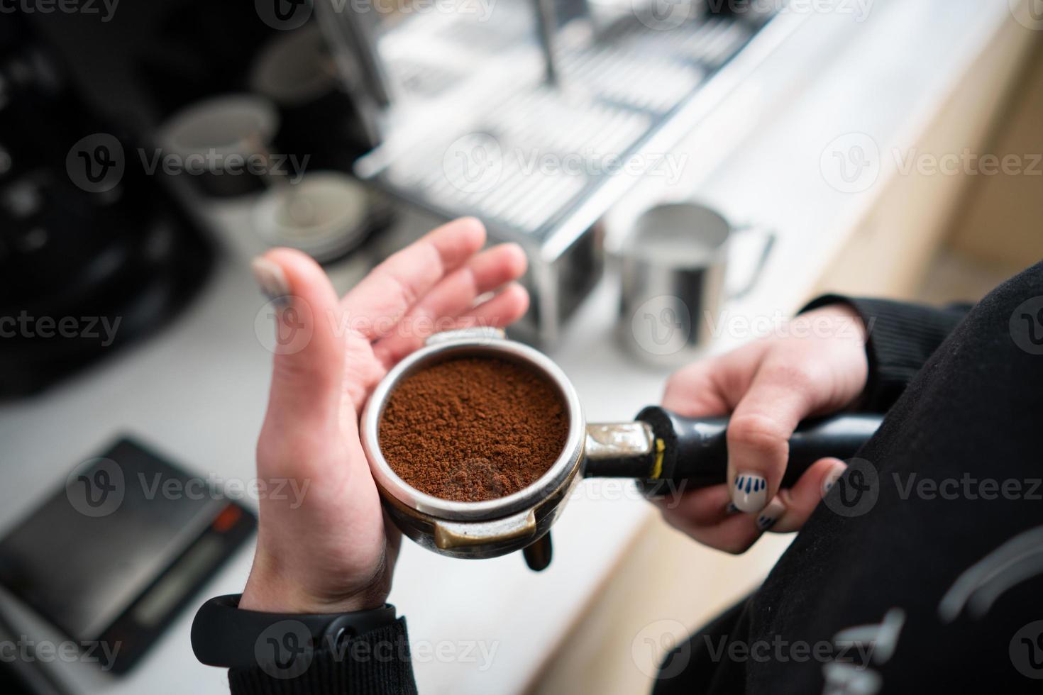 Barista holding portafilter with ground coffee photo