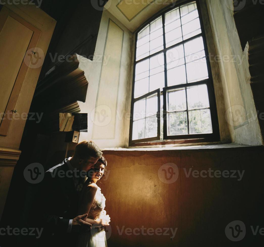 bride and groom on the background of a window. photo