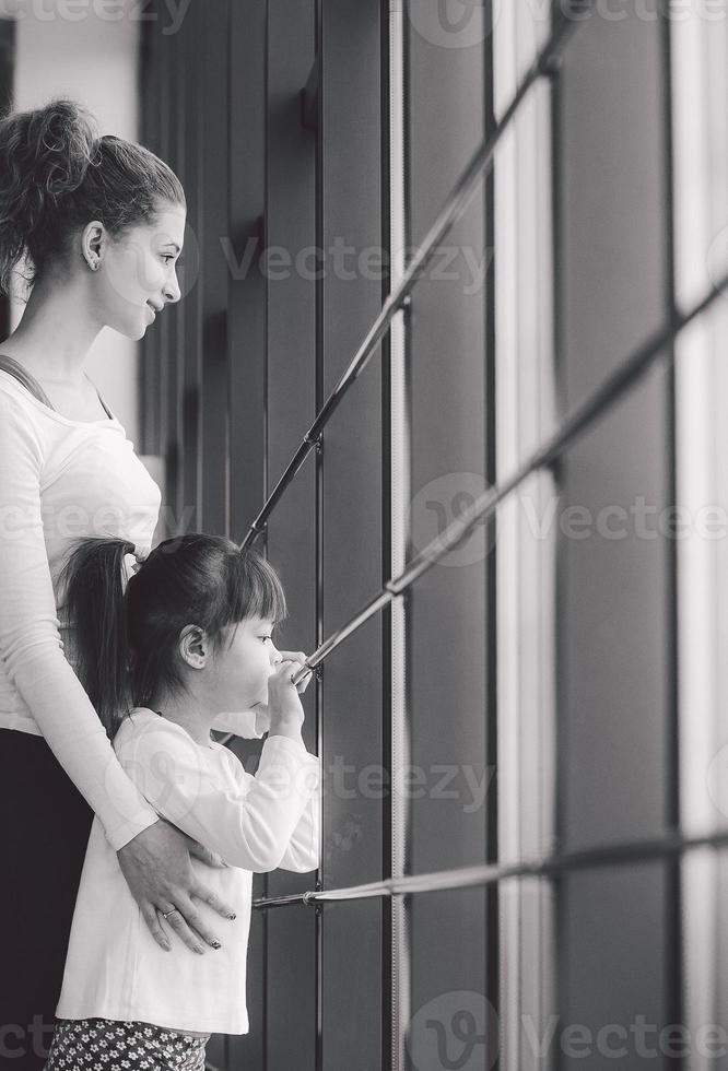 dos chicas de diferentes edades miran fijamente por una ventana en el gimnasio foto